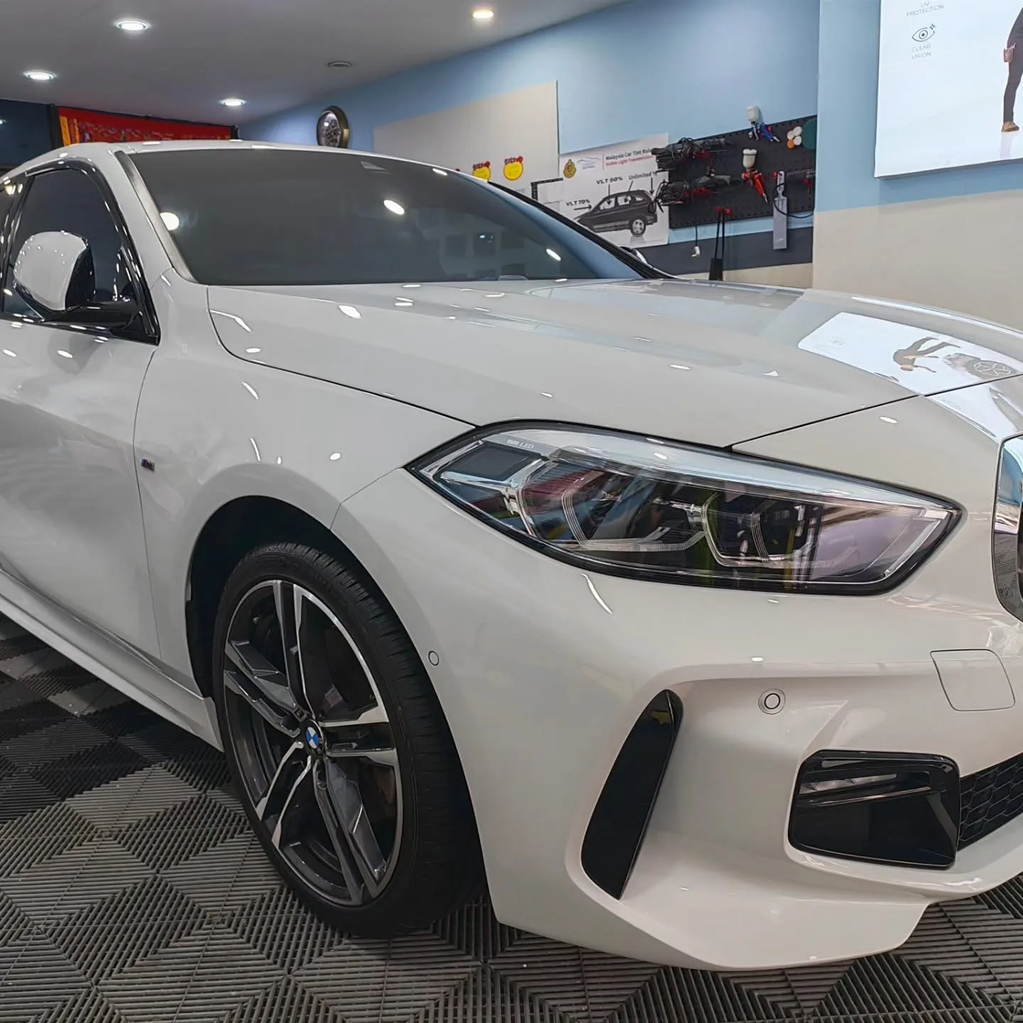 Front of the BMW 118i, showing the headlight and front hood